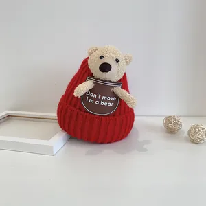 Detail of red knit baby winter hat with cute plush bear ears and soft bear patch