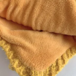 Dettaglio della maglia gialla con spessa fodera in peluche rosa per il calore invernale