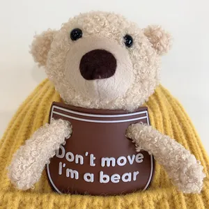 Detail of yellow knit baby hat with 3D plush bear and printed patch decoration