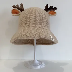 Cute knitted baby sun hat with reindeer antlers and ears in beige crochet style