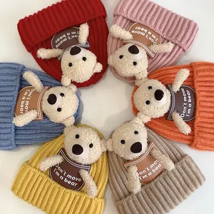 Detail view of colorful knit baby hats featuring 3D plush bears and woven texture