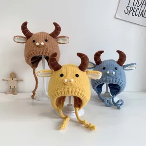 Three knit baby beanies with cute horns and ear flaps in brown, yellow and blue colors