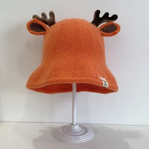 Detailed knit of orange baby bucket hat featuring brown antlers and a 'Baby' label