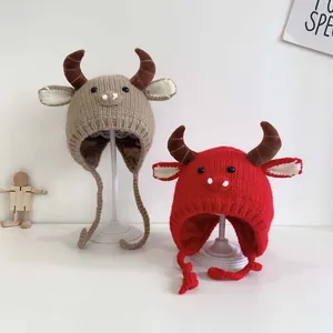 Detail of baby knitted earflap hat with cute cartoon ox horns and soft woven texture