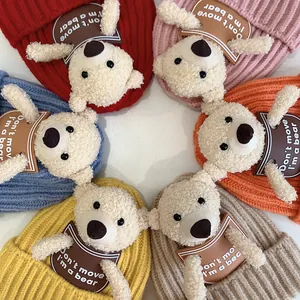 Detail view of colorful knit baby hats with cute bear patches and warm ribbed texture