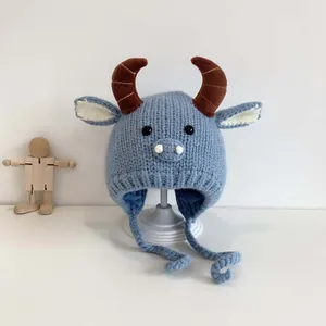 Blue knit baby winter hat with cute brown ox horns and ear flaps with ties