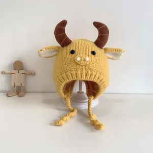 Cute yellow knitted baby hat with bull horns and ear flaps for warmth in winter