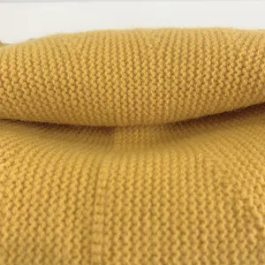 Close-up of yellow knitted fabric showing soft waffle texture and chunky knit pattern
