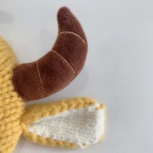 Close-up of baby winter hat showing yellow knit texture and soft brown plush horns
