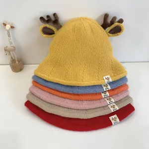 Detail showing various colors of knitted baby bucket hats with 3D deer antlers and ears