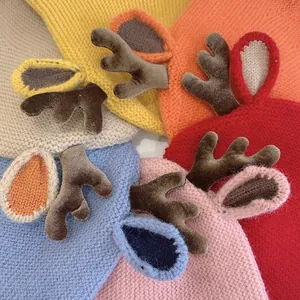 Detailed view of colorful knitted baby hats featuring cute 3D reindeer antlers and ears