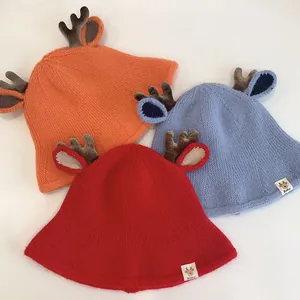 Detail of baby knit hats featuring 3D reindeer antlers and ears in orange, blue, and red