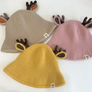 Detail of baby sun hats featuring cute reindeer antlers and knit texture in soft colors