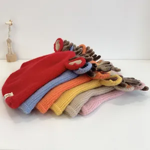 Detailed view of colorful knitted baby hats with cute brown 3D antlers and soft ears