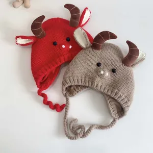Detail view of handmade baby winter knit hat with cute ox horns and cozy earmuffs