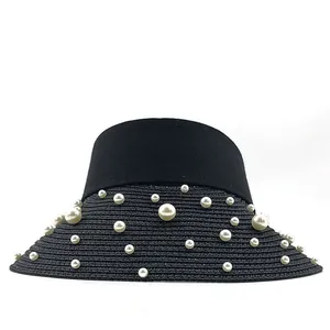 Detailed view of hand-stitched pearls on elegant black raffia straw sun visor hat