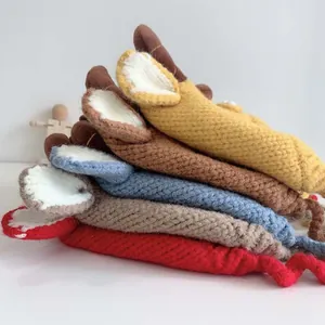 Detail showing stacked thick knit baby hats with cute 3D ears in various warm colors