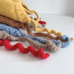 Detailed texture of multi-color knit baby hats with unique spiral curly drawstring ties