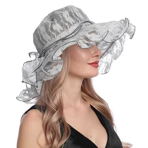 Detalle de sombrero de sol en encaje blanco con bordados florales y bordes de ribete negro