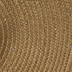 Macro view of woven raffia texture with silver bead embellishments on sun hat brim