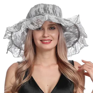 Detalle de sombrero de sol blanco de organza con encaje floral y ala ondulada