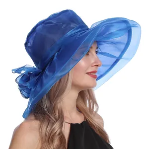 Détail d'un chapeau de soleil en organza bleu roi avec fleur élégante et large bord ondulé
