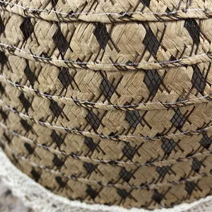 Close-up of woven straw hat featuring black diamond mesh and delicate lace trim detail