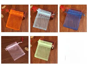 Detailed close-up of organza drawstring gift bags in multiple colors on a wooden background