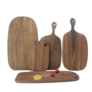 Set of five solid black walnut wood cutting boards with hanging handles for rustic kitchens
