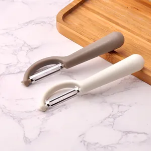 Dual stainless steel vegetable peelers in grey and beige with ergonomic handles