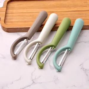 Ergonomic stainless steel vegetable peeler set in four colors on marble surface