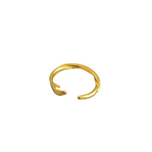 Adjustable gold hugging hands open ring made of brass with a minimalist creative design
