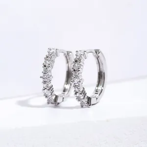 Macro shot of silver hoop earrings with clear cubic zirconia pavé setting on white background