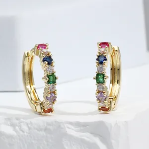Macro shot of gold hoop earrings with multi-colored square and round cubic zirconia stones