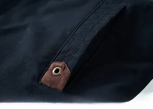 Detailed close-up of jacket pocket with twin stitching and leather trim patch