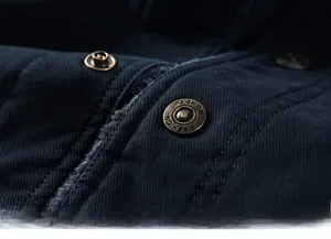 Detail of copper button with FASHION engraving on navy twill jacket with grey fleece lining
