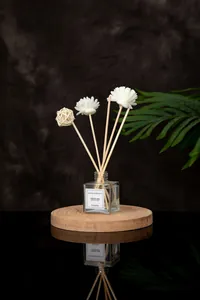Macro detail of the square glass diffuser bottle with Jasmine label and floral reeds