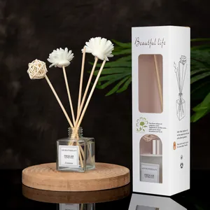 Detail of Jasmine aroma diffuser set with white daisy reeds and glass bottle on wooden base