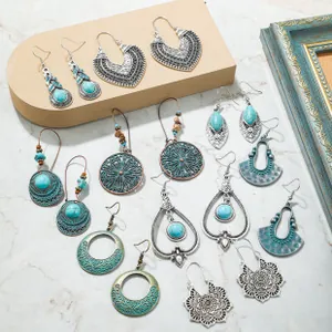 Close-up of vintage silver bohemian earring set with turquoise beads on marble background