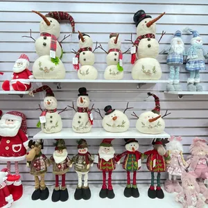 Shelf display of assorted Christmas plush figurines including snowmen and reindeer ornaments