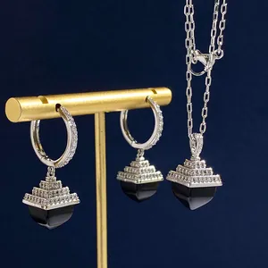 Macro detail of silver pyramid pendant set with sparkling crystals and black onyx