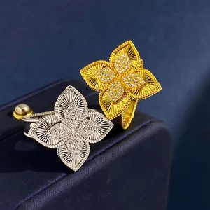 Macro view of gold and silver flower rings with radial patterns and pavé diamond centers