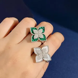 Close-up of diamond rings with malachite and mother of pearl flower petals
