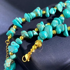 Macro-opname van onregelmatige turquoise stenen met gouden kralen en een karabijnsluiting