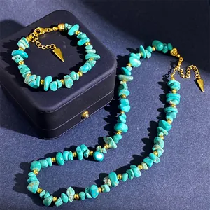 Detail van boheemse turquoise stenenset met gouden kralen en driehoekige hangers