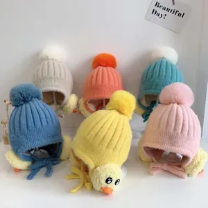 Flachbild von Baby-Strickmützen mit Bommeln und Ohrenklappen in sechs Pastellfarben