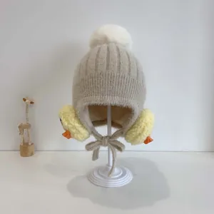 Detaillierte Ansicht der Baby-Strickmütze mit gelben Küken-Ohrenschützern und weißem Pompon