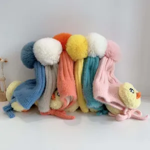 Detailansicht bunter Baby-Strickmützen mit Ohrenklappen, Bommeln und Küken-Design