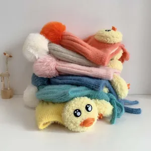 Detailansicht bunter Baby-Strickmützen mit Bommeln und süßem Enten-Design im Stapel