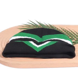 Chic black Y2K knit beanie featuring green and white chevron stripes on wooden tray